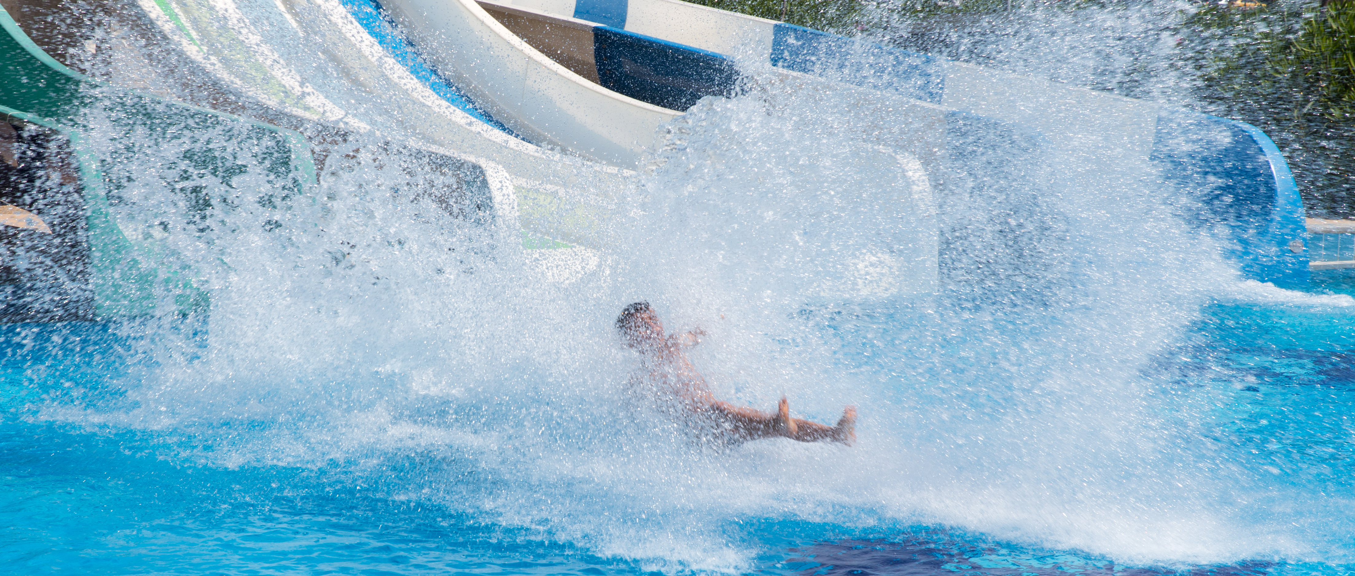 The Markets Corner: Water. A person splashes into the pool at the bottom of a waterslide.