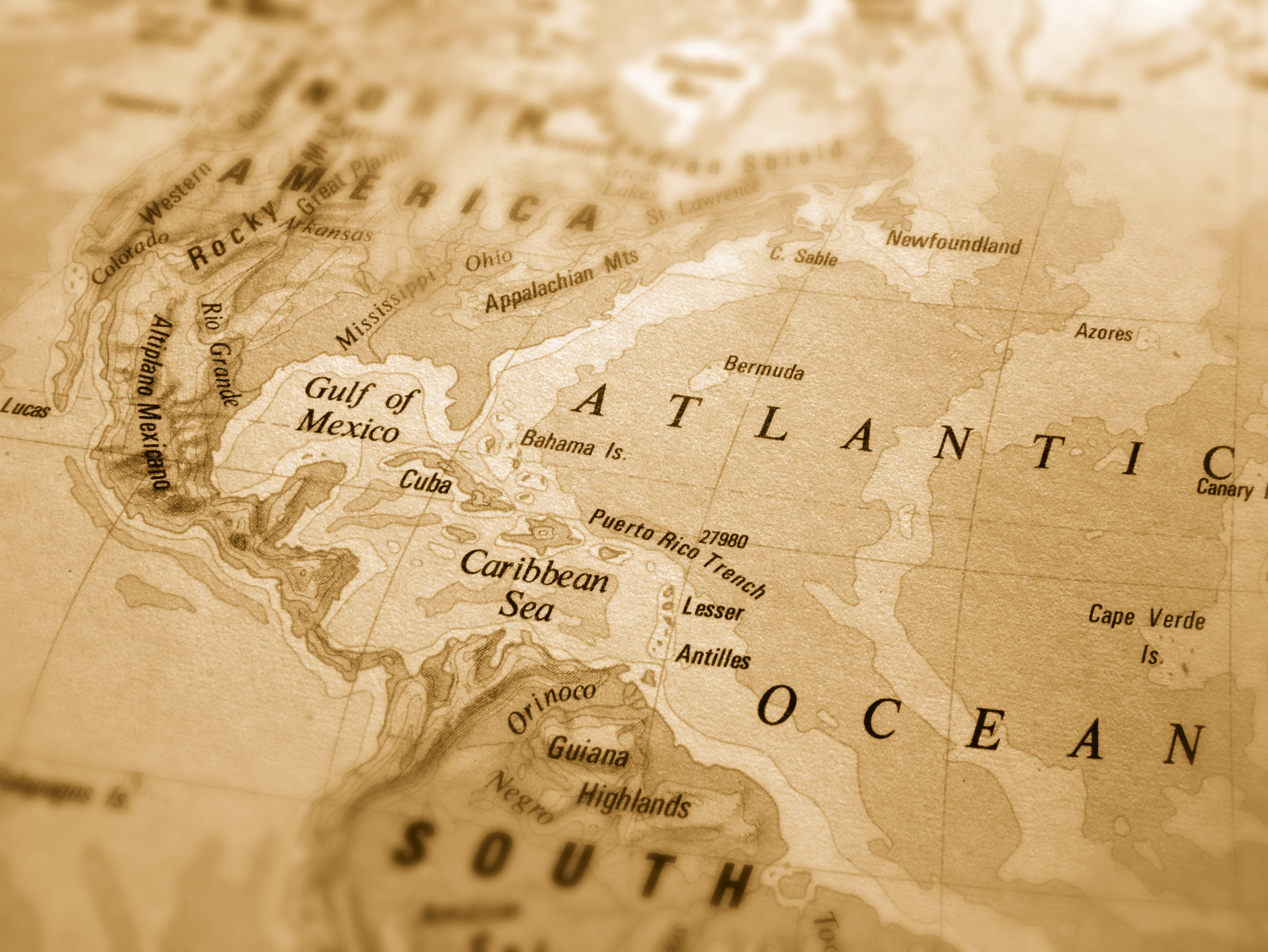 Section of a sepia-toned map showing North America, part of South America, and the Atlantic Ocean.