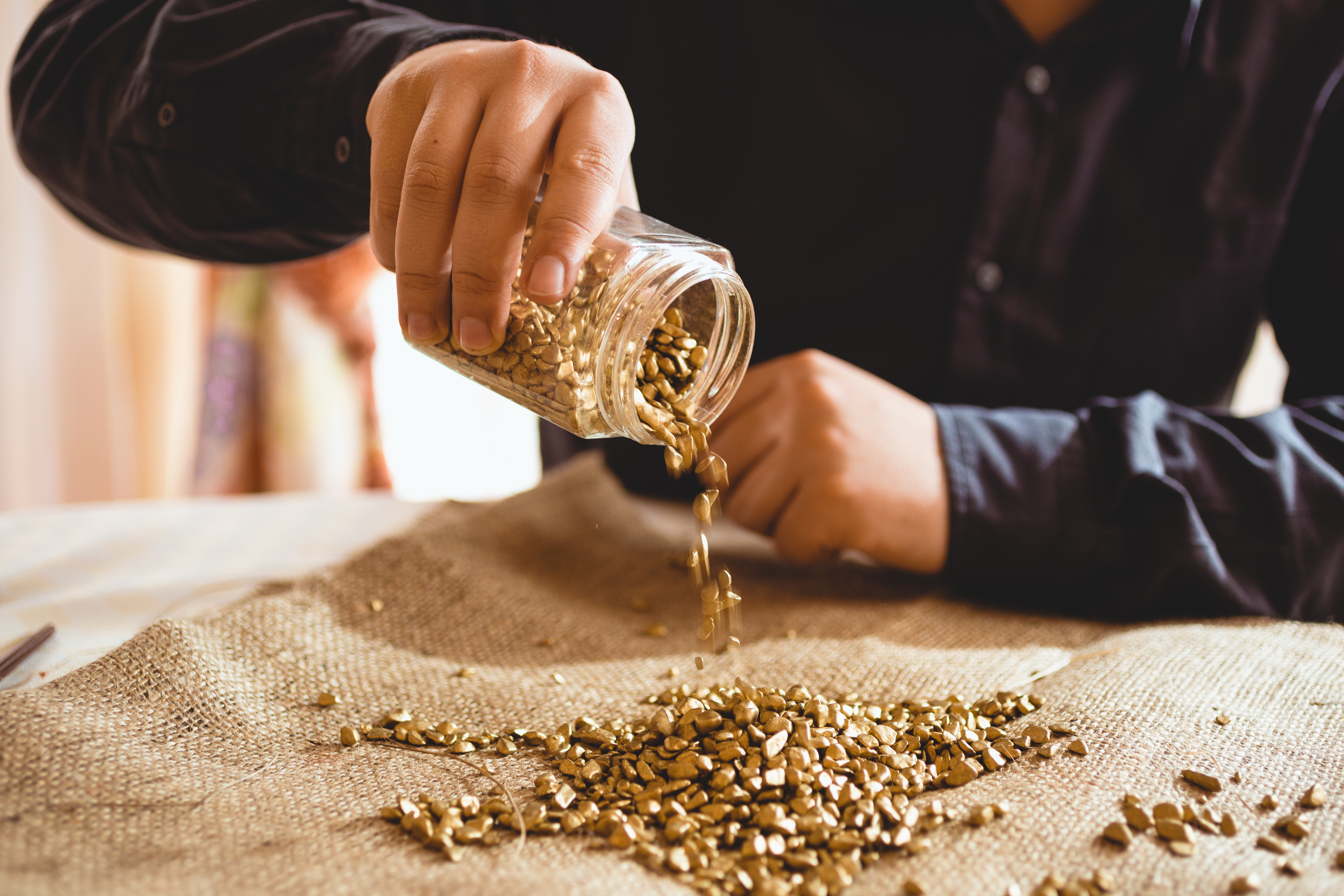 Chart View - Gold Futures. Male miner pouring gold out of a jar.