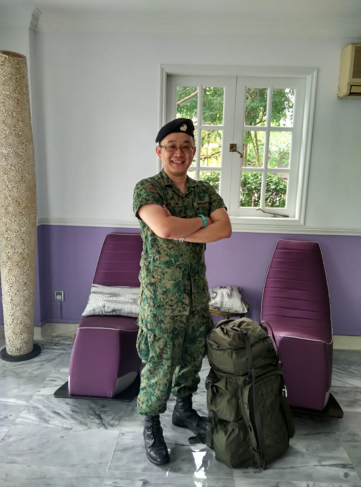 Singaporean man posing in his uniform at home.