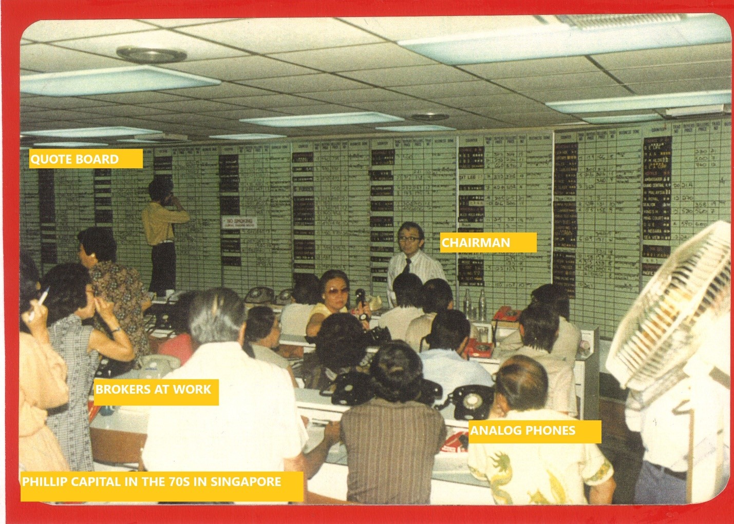 Image of Phillip Capital staff working in the office in the 1970s. Tags on the image label the Chairman, the quote board, brokers at work, and analog phones.