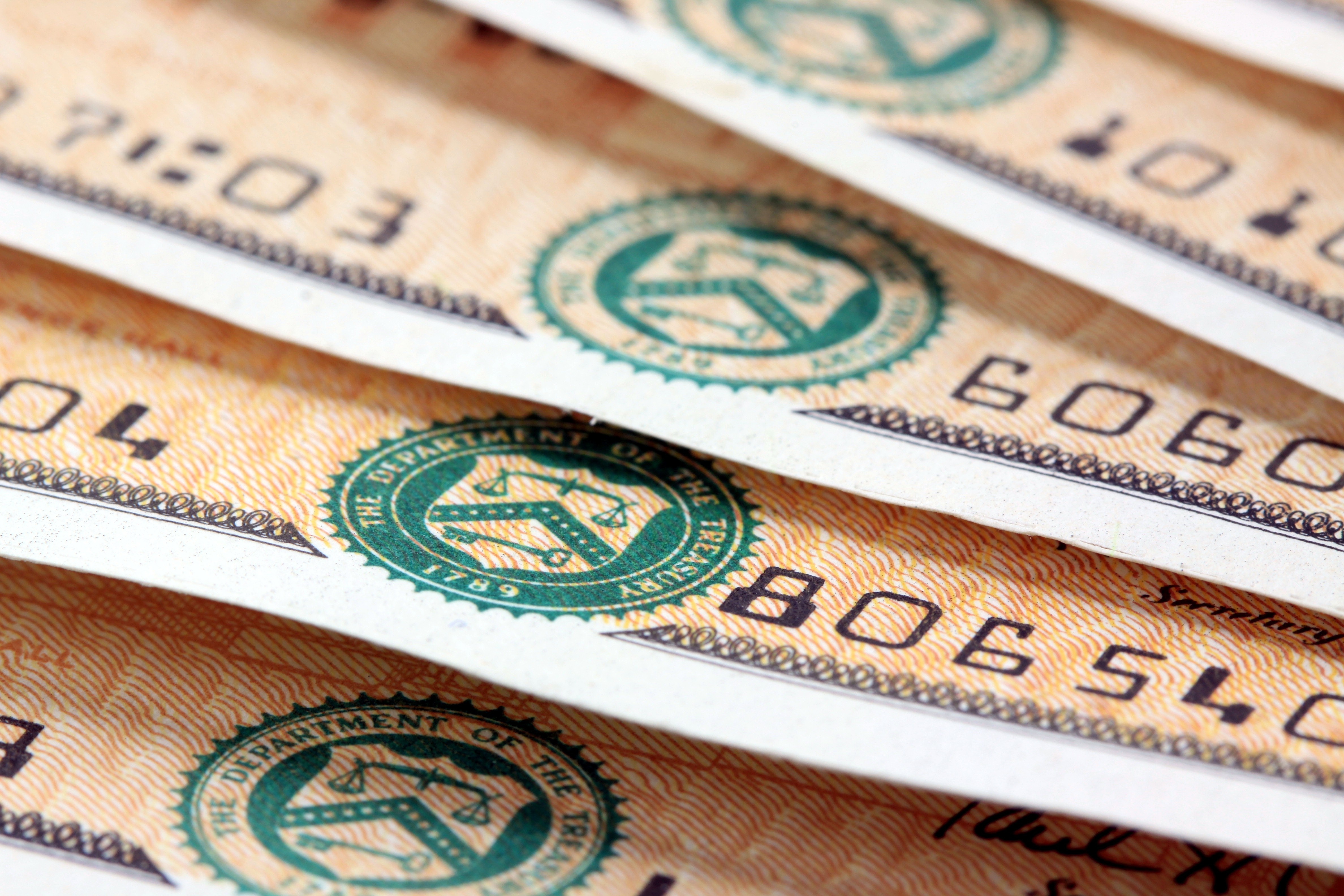 Close-up photo of the bottom edges of U.S. Treasury savings bonds, showing Treasury seal and serial numbers.